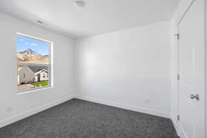 Unfurnished bedroom with dark carpet and a textured ceiling