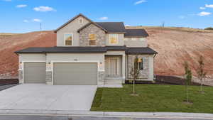 View of front facade featuring a front lawn and a garage