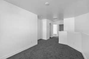 Carpeted spare room with a textured ceiling