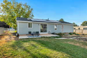 Rear view of house featuring a lawn and a patio area