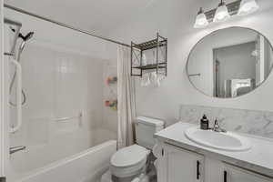 Full bathroom with vanity, toilet, and shower / bath combo with shower curtain