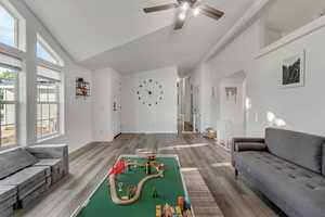 Rec room with hardwood / wood-style flooring, high vaulted ceiling, and ceiling fan