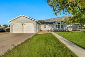 Ranch-style house with a mountain view, a front yard, and a garage