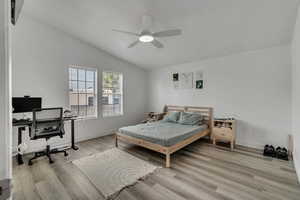 Bedroom featuring vaulted ceiling, ceiling fan, and light hardwood / wood-style flooring