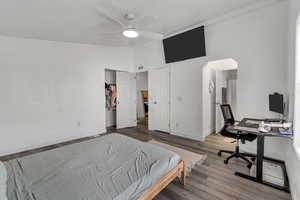 Bedroom with hardwood / wood-style flooring, ceiling fan, and high vaulted ceiling