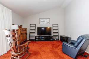 Living room with vaulted ceiling and carpet flooring