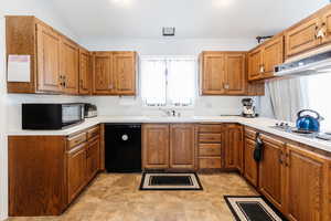 Kitchen featuring vaulted ceiling, sink, and black appliances