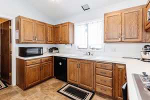 Kitchen with sink, vaulted ceiling, and black appliances