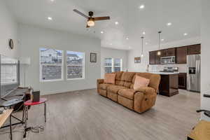 Living room with ceiling fan, sink, and light hardwood / wood-style floors