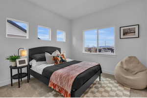 Bedroom with baseboards and light colored carpet