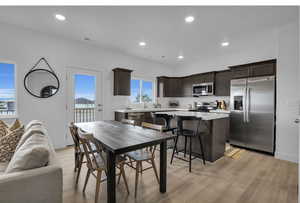 Dining area with baseboards, light wood finished floors, visible vents, and recessed lighting