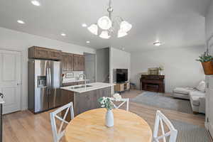 Dining area and family room with light hardwood / wood-style flooring, sink, and a chandelier