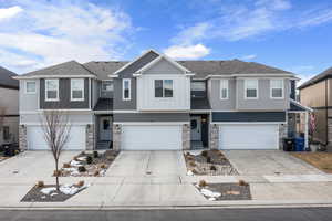 View of front of house featuring two car garage. HOA takes care of snow removal and yard.