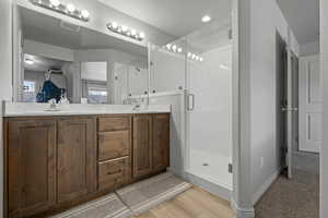 Primary bedroom/bathroom suite with two sinks and walk in shower