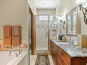 Bathroom featuring tile patterned floors, vanity, and independent shower and bath