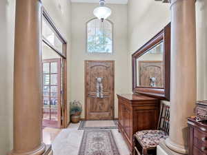 Entrance foyer with decorative columns, plenty of natural light, and a high ceiling