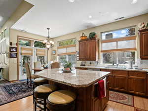 Kitchen featuring tasteful backsplash, sink, light hardwood / wood-style flooring, and a kitchen island