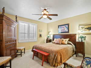 Carpeted bedroom featuring ceiling fan