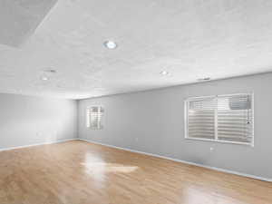 Unfurnished room featuring light hardwood / wood-style flooring and a textured ceiling