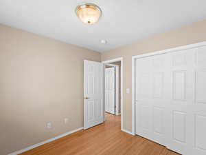 Unfurnished bedroom featuring light hardwood / wood-style floors and a closet