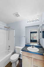 Full bathroom with shower / tub combination, tile patterned flooring, vanity, a textured ceiling, and toilet