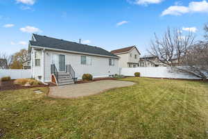 Back of house with a patio area and a lawn