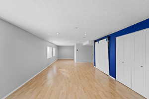 Interior space featuring a barn door, light hardwood / wood-style floors, and a textured ceiling