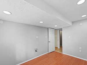 Spare room with a textured ceiling and light hardwood / wood-style floors