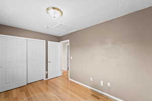 Unfurnished bedroom featuring light wood-type flooring and a closet