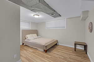 Bedroom with a textured ceiling and light hardwood / wood-style floors