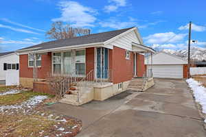 View of front of property featuring a garage, a mountain view, and an outdoor structure