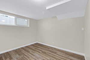 Unfurnished room with hardwood / wood-style flooring and a textured ceiling