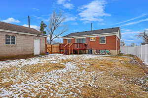 Snow covered house featuring a deck and cooling unit