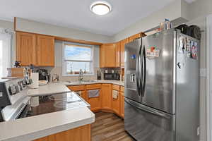 Kitchen with sink, appliances with stainless steel finishes, and wood-type flooring