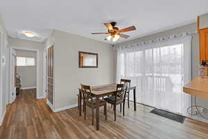 Dining room with ceiling fan and wood-type flooring