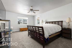 Bedroom featuring ensuite bathroom, ceiling fan, and carpet floors