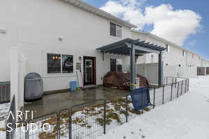 Snow covered property featuring a pergola