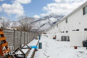 Yard covered in snow featuring a mountain view