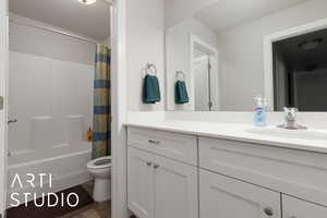 Full bathroom with shower / bath combination with curtain, vanity, and toilet