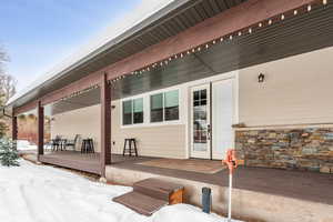 Snow covered property entrance featuring a composite deck