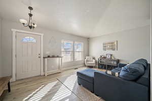 Living room featuring light hardwood / wood-style flooring and a notable chandelier