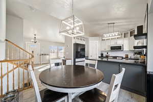 Dining space with light hardwood / wood-style flooring and a notable chandelier