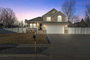 View of front of home with covered porch and a garage