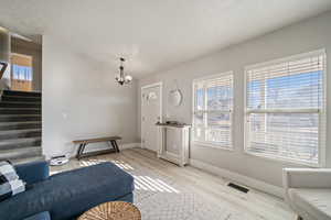 Living room with light hardwood / wood-style flooring and a chandelier