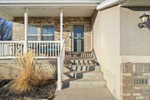 Doorway to property with covered porch