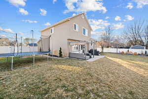 Back of house with an outdoor hangout area, a trampoline, a patio area, and a yard