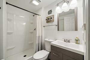 Bathroom featuring vanity, a shower with curtain, and toilet