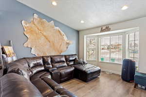 Living room featuring light hardwood / wood-style floors and a textured ceiling