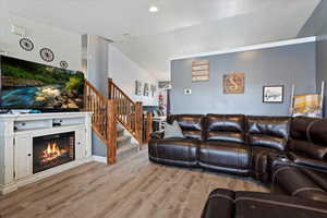 Living room with light wood-type flooring and vaulted ceiling