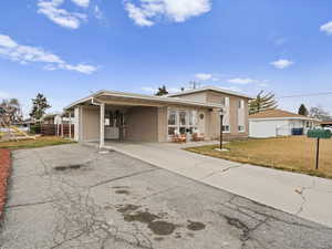 View of front facade with a front lawn and a carport